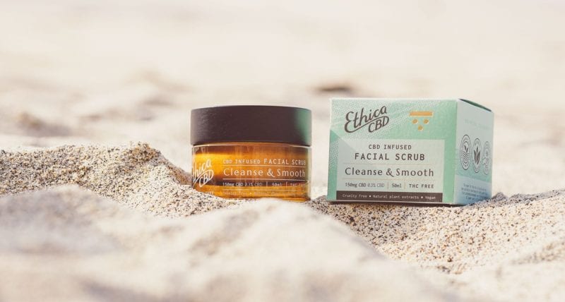EthicaCBD facial scrub sat in the sand