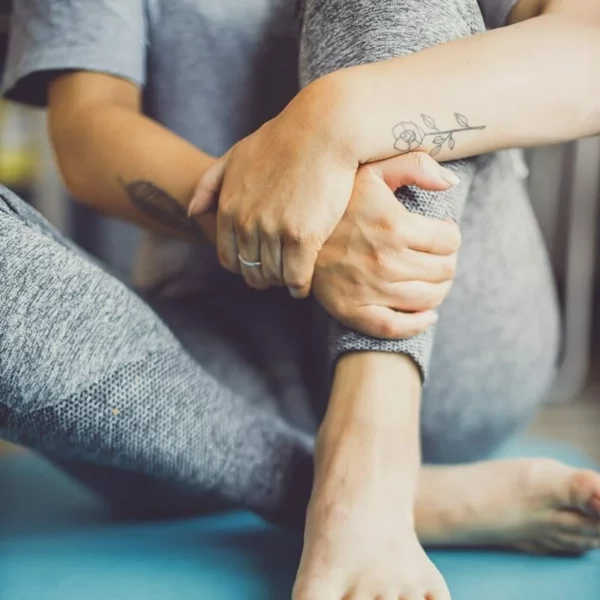 Women in gym sitting holding ankle